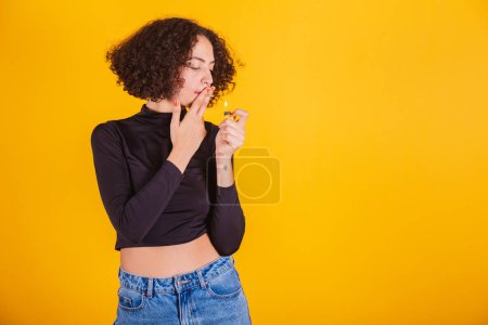 Téléchargez les photos : Modèle caucasien, portant une chemise noire et un jean bleu, fumant une cigarette. - en image libre de droit