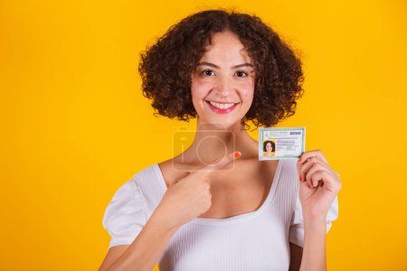 Photo for Caucasian model, wearing white shirt and blue jeans, holding nationality and identity card, translation in English (identity card) - Royalty Free Image