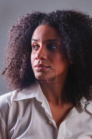 Photo for Half body portrait, black brazilian woman, white shirt closeup portrait, looking left. - Royalty Free Image