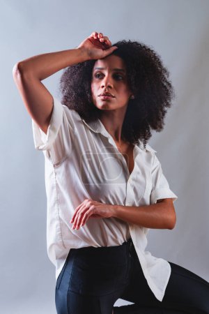 Foto de Medio cuerpo retrato, mujer brasileña negro, camisa blanca foto en pose de moda. Modelo. - Imagen libre de derechos