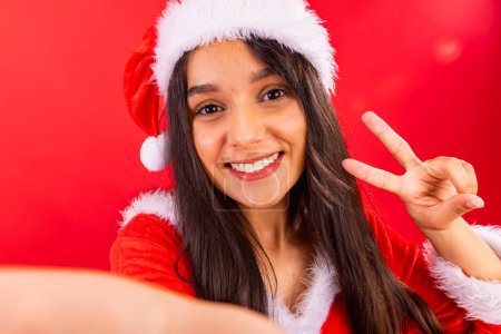 Photo for Brazilian woman, teenager, wearing Christmas clothes, peace and love, fingers. - Royalty Free Image