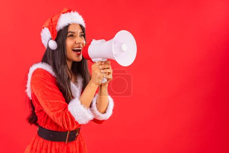Téléchargez les photos : Femme adolescente brésilienne portant des vêtements de Noël, avec mégaphone annonçant la promotion. - en image libre de droit