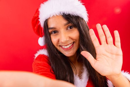 Téléchargez les photos : Femme adolescente brésilienne portant des vêtements de Noël, souriant à la caméra pour un selfie. - en image libre de droit
