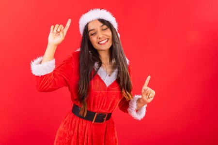 Foto de Adolescente brasileña vistiendo ropa de Navidad, sonriendo, bailando. - Imagen libre de derechos