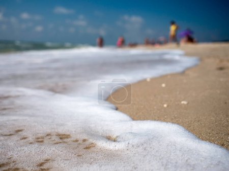 Photo for Tidal wave sea foam on sandy beach. Background - Royalty Free Image