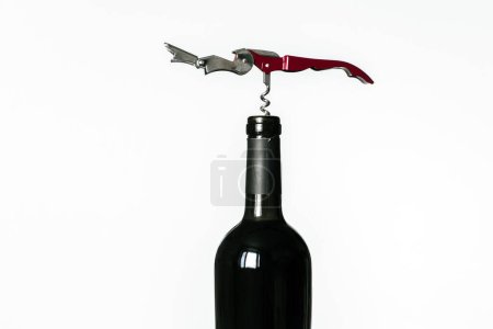 Photo for Corkscrew screwed into the cork of a bottle of red wine isolated on a white background - Royalty Free Image