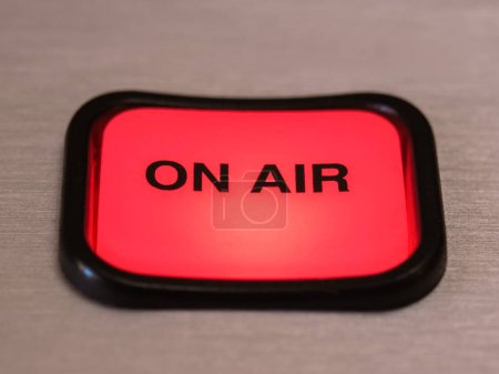Foto de Primer plano del botón rojo luminoso ON AIR en la consola digital del estudio de radiodifusión - Imagen libre de derechos