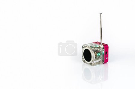 Téléchargez les photos : Un petit récepteur radio en forme de cube sur fond blanc avec réflexion - en image libre de droit