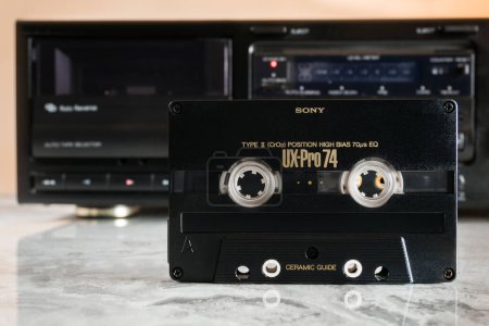 Téléchargez les photos : Zaporizhzhia, Ukraine - 24 décembre 2023 : Sony UX-PRO 74 cassette audio debout devant un pont de cassettes sur une table en marbre poli avec réflexion - en image libre de droit