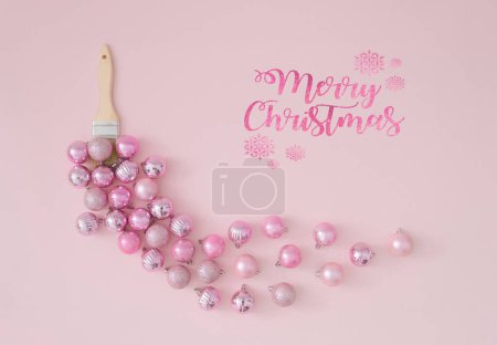 Creative trendy layout made of paint brush with pink Christmas baubles on pastel pink background. Minimal Christmas or New Year decoration concept. Winter holidays celebration idea. Flat lay.