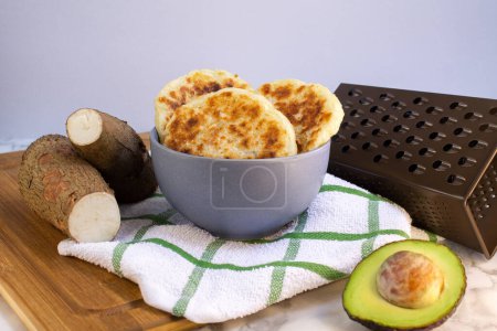 Téléchargez les photos : Arepas de yuca y queso tradicionales ecuatorianas, servidas para un desayuno saludable y gluten free, con aguacate y queso, sobre madera - en image libre de droit