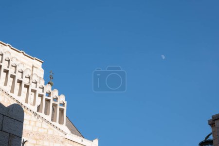 Téléchargez les photos : Nazareth, Israël - 16 août 2021 : façade de l'église de Nazareth avec une lune dans le ciel. Photo de haute qualité - en image libre de droit