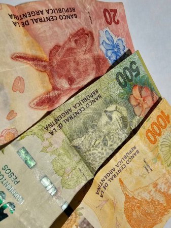 Moneda en billetes amarillos, verdes y rojos, gastados en efectivo de Argentina