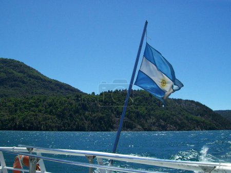 Argentinische Nationalflagge vor natürlichem Hintergrund von See und Bergen