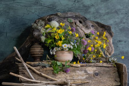un bouquet de fleurs sauvages dans un pot d'argile, dans un style ethnique