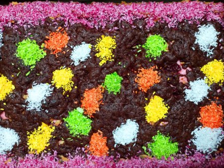 Photo for Decoration on the surface of the sweets. A delicious sponge cake decorated with colorful shavings on a chocolate base. - Royalty Free Image