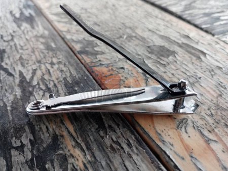 Photo for Metal nail clippers for cutting nails lie on an old table. Special nippers for hand hygiene. - Royalty Free Image