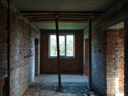 Bâtiment inachevé de l'intérieur. Couloir d'un bâtiment en brique pendant les travaux de construction. Le processus de construction d'une maison en brique rouge d'argile.
