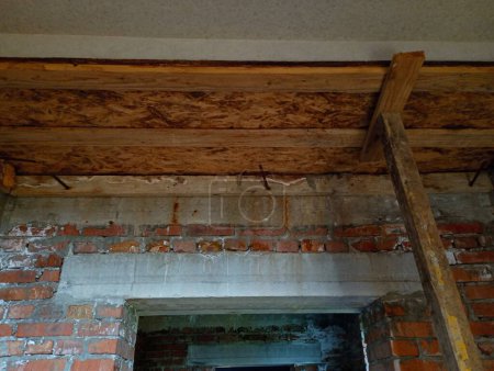 Téléchargez les photos : Coffrage au plafond soutenu par des supports d'une dalle de bois pour couler le béton. Coffrage sur le chantier sur fond de murs de briques. Le thème de la construction. - en image libre de droit