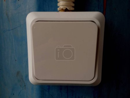 Téléchargez les photos : Interrupteur électrique blanc sur vieux mur brûlé bleu. Le thème des appareils électriques. - en image libre de droit