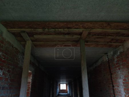 Photo for Wooden supports in the ceiling for pouring concrete into the corridors of a new brick building. The topic of building new houses for people to live in - Royalty Free Image