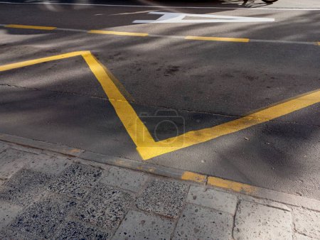 Yellow road markings. Applying yellow lines on the asphalt surface. Zone for the movement of city transport.