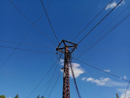 Foto de Polo de metal en el fondo del cielo azul con muchos cables eléctricos y cables de Internet. El tema de las comunicaciones. - Imagen libre de derechos