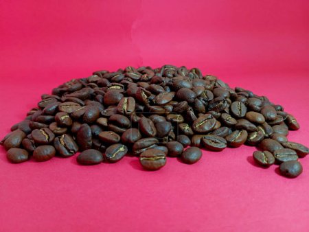 Una pequeña colina de granos de café sobre un fondo rojo brillante. El tema de las bebidas y granos de café.