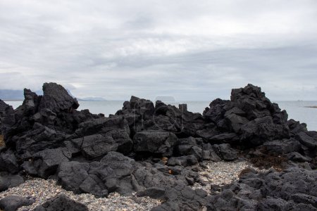 Ein felsiges Ufer des südisländischen Strandes mit schwarzen vulkanischen Felsen an der isländischen Südküste