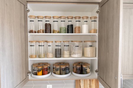 Foto de Despensa de alimentos etiquetados cuidadosamente organizada en una cocina casera con especias granos harina arroz azúcar nueces - Imagen libre de derechos