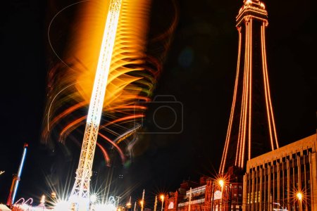 Foto de Larga exposición de un paseo de carnaval giratorio por la noche con senderos iluminados contra un cielo oscuro. - Imagen libre de derechos
