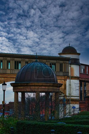 Cielo dramático sobre una cúpula arquitectónica y edificio con un puente al fondo en Harrogate, Inglaterra.