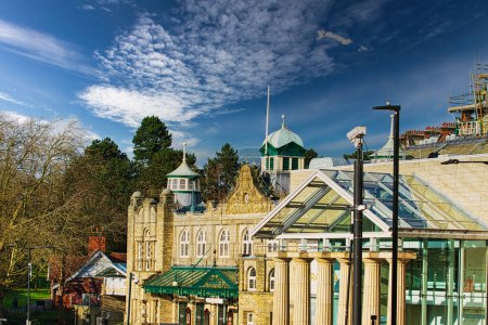 Journée ensoleillée sur des bâtiments historiques avec ciel bleu et nuages duveteux à Harrogate, Angleterre.