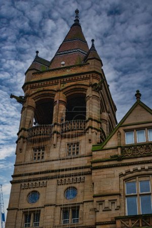 Viktorianische Architektur mit einem detaillierten Turm unter wolkenverhangenem Himmel in Leeds, Großbritannien.