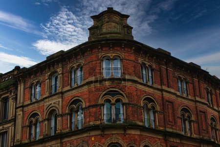 Victorian architecture with ornate windows against a cloudy sky in Leeds, UK.