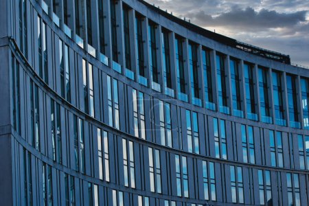 Façade moderne d'immeubles de bureaux avec vitres réfléchissantes contre un ciel nuageux au crépuscule à Liverpool, Royaume-Uni.