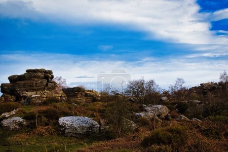 Vista panorámica de formaciones rocosas bajo un cielo azul dramático con nubes en Brimham Rocks, en Yorkshire del Norte