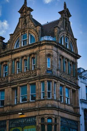 Victorian architecture with ornate details on a historic building's facade against a blue sky in Leeds, UK.