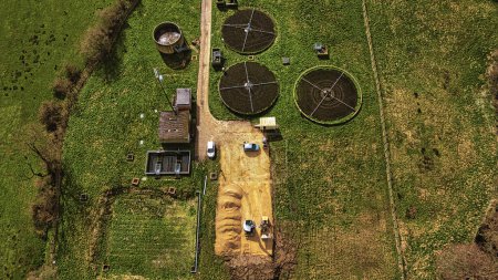 Aerial view of a wastewater treatment plant with circular tanks in a green field in North Yorkshire.