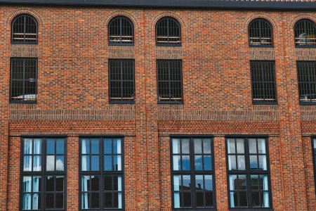 Foto de Fachada de un edificio de ladrillo vintage con filas de ventanas que reflejan el cielo, mostrando la arquitectura industrial en York, Yorkshire del Norte, Inglaterra. - Imagen libre de derechos