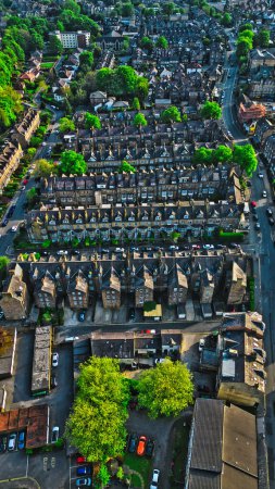 Vista aérea de un barrio residencial con filas de casas, calles y árboles verdes.