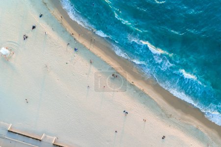 Foto de Vista aérea de arriba hacia abajo de la playa y el agua azul clara. Ondas oceánicas en la playa como fondo. Hermosa vacaciones de verano natural fondo de vacaciones. City Beach, Australia Occidental. Paisajes marinos costeros - Imagen libre de derechos