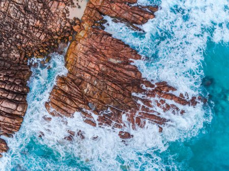 Photo for Aerial top down view of rocks and clear blue water. Ocean waves smashing on the rocks as a background. Beautiful natural winter vacation holidays background. Margaret River, Western Australia. Coastal seascapes - Royalty Free Image