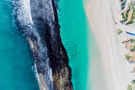 Téléchargez les photos : Paysage marin d'été belles vagues, eau de mer bleue dans une journée ensoleillée. Vue de dessus depuis un drone. Vue aérienne de la mer turquoise sur le récif, fond naturel tropical étonnant. Belle mer éclaboussures de vagues lumineuses et plage de sable lumière du soleil. Yanchep Reef, Australie occidentale. - en image libre de droit