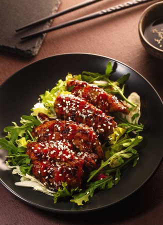 Asian style spicy chicken on fresh lettuce leaves. High quality photo.