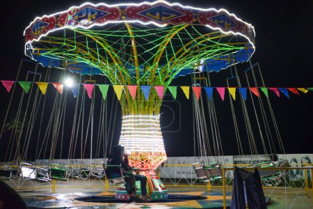 Foto de Paseos en silla giratoria voladora o volando Ontang o columpios de sillas voladoras de colores en los paseos del mercado nocturno - Imagen libre de derechos