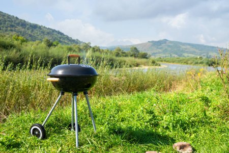 Barbecue, charcoal grill on the river bank. Relaxation, cooking in the fresh air. Summer rest. Background.