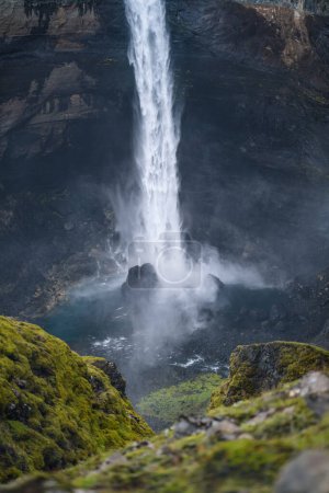Téléchargez les photos : Fermeture de la cascade Haifoss dans le sud de l'Islande. L'eau s'écrase contre les rochers sur le fond et éclabousse autour. Premier plan déconcentré. - en image libre de droit