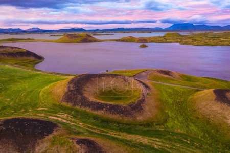 Aerial panoramic view of Myvatn, Iceland at epic sunset. Volcanic Craters In Green Plaints and link clouds and sky.