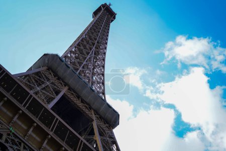 Photo for Eiffel Tower in low angle with blue cloudly sky - Royalty Free Image